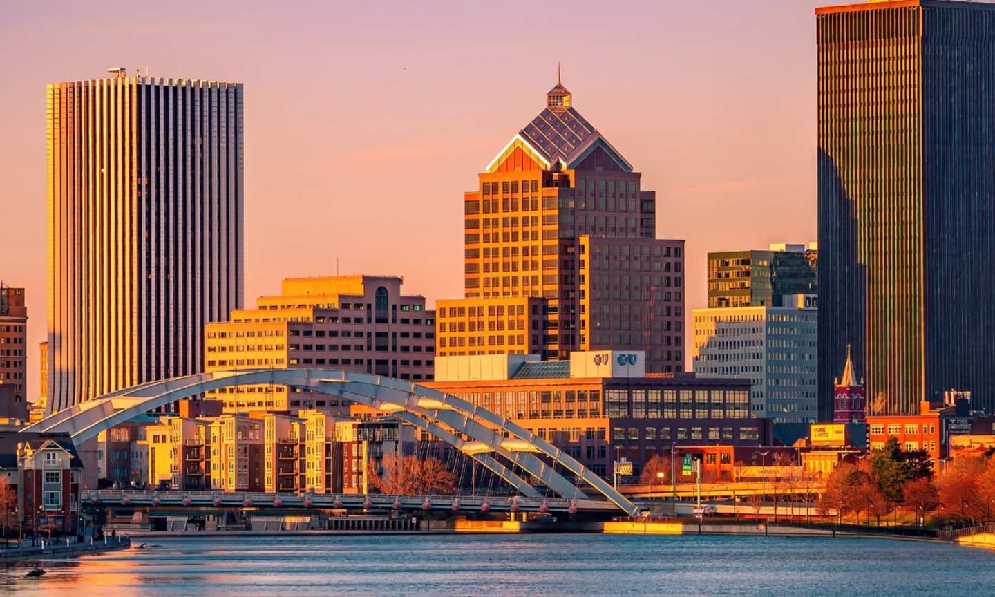 The Rochester skyline across the Genesee River, with the Frederick Douglass–Susan B. Anthony Memorial Bridge in the foreground